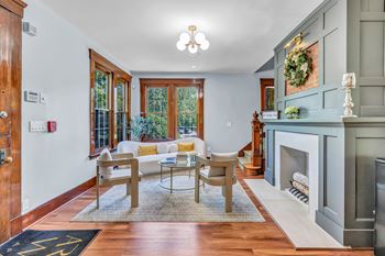 A living room with a fireplace and a dining table.